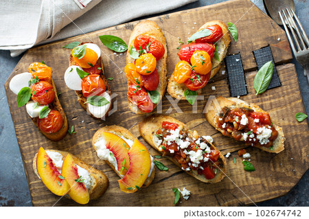 Crostini or bruschetta board with caprese, tomatoes and peaches Crostini or bruschetta board with caprese, tomatoes and peaches 102674742