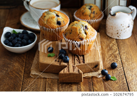 Freshly baked blueberry muffins in a rustic setting Freshly baked blueberry muffins in a rustic setting 102674795