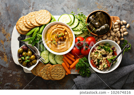 Hummus and vegetables platter with grain salad 102674816