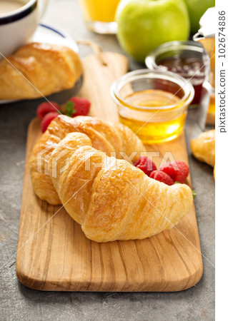 Freshly baked croissants with honey and jam Freshly baked croissants with honey and jam 102674886