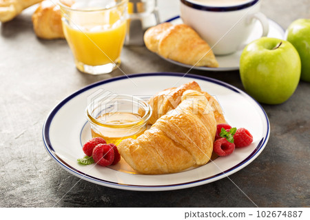 Freshly baked croissants with honey and jam Freshly baked croissants with honey and jam 102674887