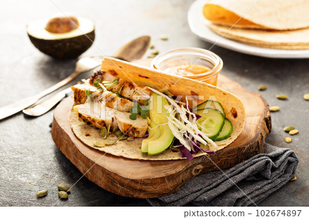 Making tacos with grilled chicken and avocado Making tacos with grilled chicken and avocado 102674897