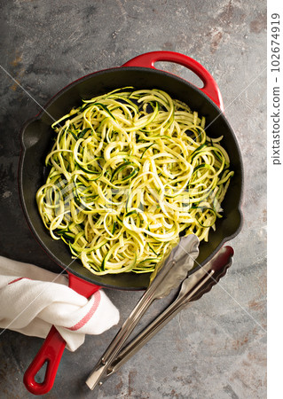 Spiralized zucchini noodles in a cast iron pan Spiralized zucchini noodles in a cast iron pan 102674919