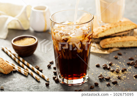 Iced coffee being poured in a glass Iced coffee being poured in a glass 102675095