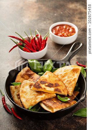 Cheese quesadillas in a cast iron pan 102675458