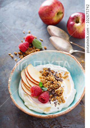 Yogurt bowl with raspberry and granola 102675742