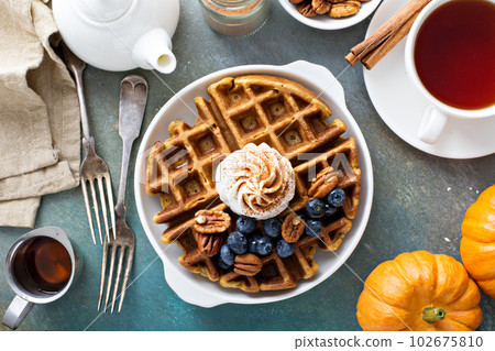 Pumpkin waffles with whipped cream for breakfast Pumpkin waffles with whipped cream for breakfast 102675810