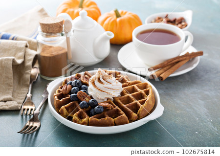 Pumpkin waffles with whipped cream for breakfast Pumpkin waffles with whipped cream for breakfast 102675814