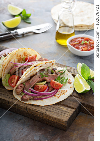 Steak tacos with sliced meet, salad and tomato salsa Steak tacos with sliced meet, salad and tomato salsa 102676721