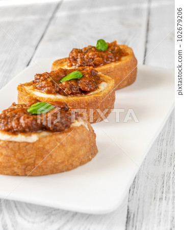 Ciabatta bruschettas with mozzarella and puttanesca Ciabatta bruschettas with mozzarella and puttanesca 102679206