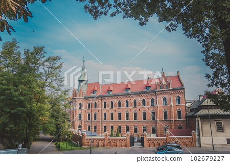 The Neo-Gothic building with orange brick wall and red roof with spire The Neo-Gothic building with orange brick wall and red roof with spire 102679227