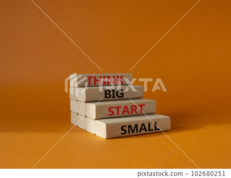 Think big start small symbol. Concept words Think big start small on wooden blocks. Beautiful orange background. Business and Think big start small concept. Copy space 102680251