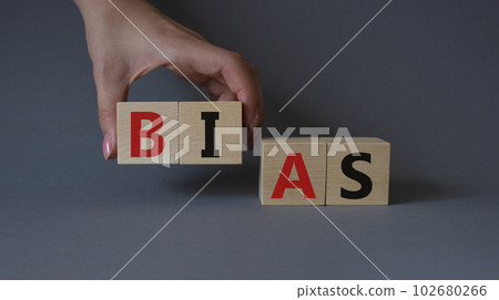 Bias symbol. Concept word Bias on wooden cubes. Businessman hand. Beautiful grey background. Business and Bias concept. Copy space. Bias symbol. Concept word Bias on wooden cubes. Businessman hand. Beautiful grey background. Business and Bias concept. Copy space. 102680266