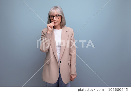 60s middle-aged woman in a stylish laconic jacket on a studio background with copy space 102680445