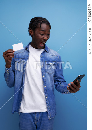 charismatic american man with black dreadlocks uses app to pay online 102680449