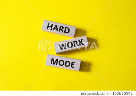 Hard Work Mode symbol. Concept word Hard Work Mode on wooden blocks. Beautiful yellow background. Business and Hard Work Mode concept. Copy space 102680542