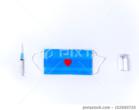 Medical flat lay with vaccine bottle, syringe and protective mask 102680720