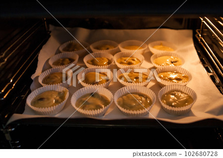 Paper cases filled with muffin dough 102680728