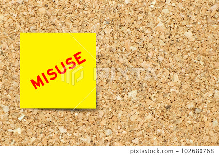Yellow note paper with word misuse on cork board background with copy space 102680768