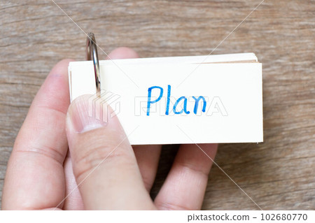 Hand hold flash card with handwriting in word plan on wood background 102680770