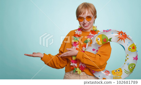 Traveler tourist woman girl hold swimming ring, celebrating, pointing empty advertising area place Traveler tourist woman girl hold swimming ring, celebrating, pointing empty advertising area place 102681789