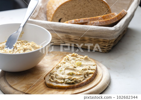 cracklings spread with pickled cucumber on slice of bread 102682344