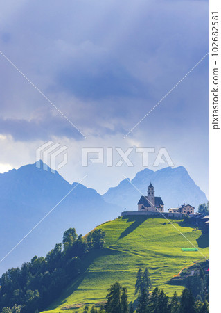 Mountainous landscape with villages of Colle Santa Lucia with church in Dolomites, South Tyrol, Italy Mountainous landscape with villages of Colle Santa Lucia with church in Dolomites, South Tyrol, Italy 102682581