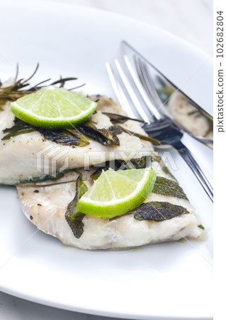 white fish fillet baked with herbs 102682804