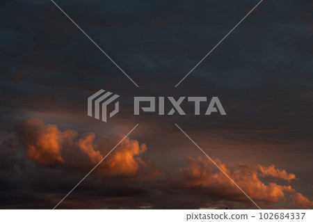 Orange and red cloudy sky at dusk in spring. Orange and red cloudy sky at dusk in spring. 102684337