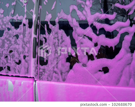 Covered auto with pink foam at a self-service car wash 102688670