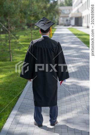 Rear view of an elderly man in a graduation gown. Rear view of an elderly man in a graduation gown. 102689068