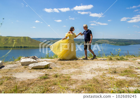 A young couple dancing on a cliff by the bay 102689245