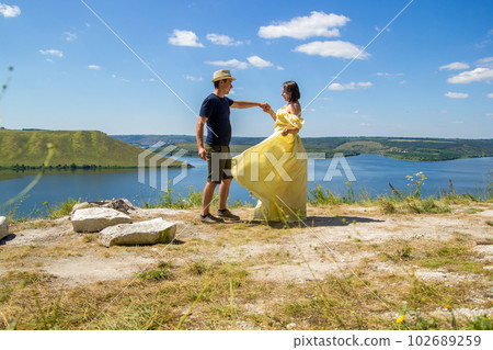 A young couple dancing on a cliff by the bay 102689259