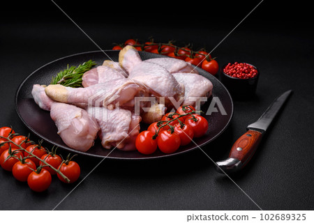 Raw chicken legs with salt, spices and herbs 102689325