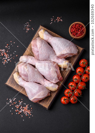 Raw chicken legs with salt, spices and herbs 102689340