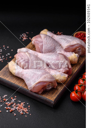 Raw chicken legs with salt, spices and herbs 102689341