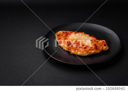 Grilled chicken fillet in the form of a steak with tomatoes, pineapple and cheese 102689342