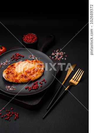 Grilled chicken fillet in the form of a steak with tomatoes, pineapple and cheese Grilled chicken fillet in the form of a steak with tomatoes, pineapple and cheese 102689372