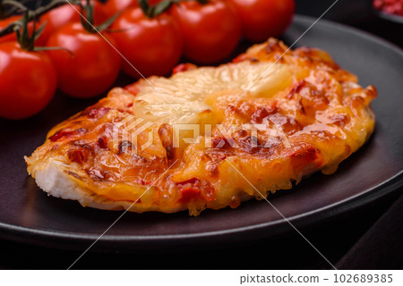 Grilled chicken fillet in the form of a steak with tomatoes, pineapple and cheese Grilled chicken fillet in the form of a steak with tomatoes, pineapple and cheese 102689385