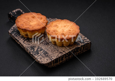 Delicious baked cupcake or tartlet with cheese and raisins Delicious baked cupcake or tartlet with cheese and raisins 102689570