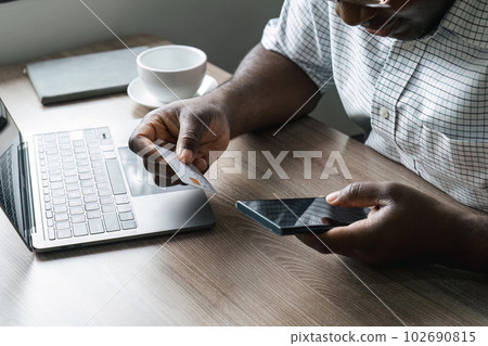 Man hand holding credit card and using mobile phone at home, Businessman or entrepreneur working, Online shopping, e-commerce, internet banking, spending money, working from home concept Man hand holding credit card and using mobile phone at home, Businessman or entrepreneur working, Online shopping, e-commerce, internet banking, spending money, working from home concept 102690815