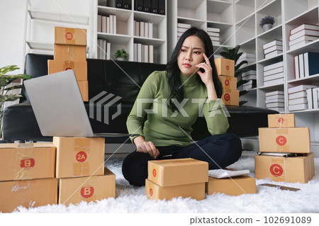 Young startup small business entrepreneur woman packing package post shipping box preparing delivery parcel , Online business, ecommerce and delivery concept. stressed headache Young startup small business entrepreneur woman packing package post shipping box preparing delivery parcel , Online business, ecommerce and delivery concept. stressed headache 102691089