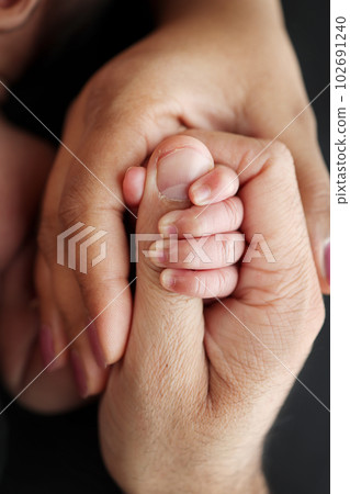 Close-up of the small hand of the child and the hand of the mother and father. Close-up of the small hand of the child and the hand of the mother and father. 102691240