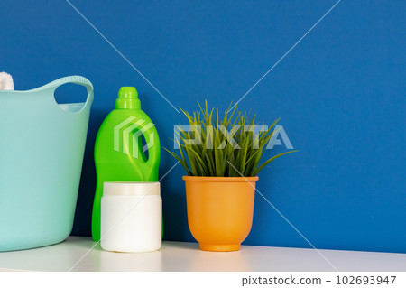 Bottle of detergent whith washing machine, indoors Bottle of detergent whith washing machine, indoors 102693947