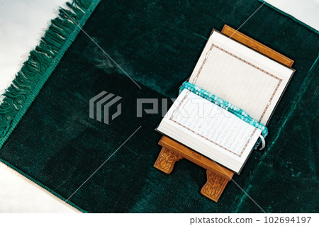 Holy Quran with prayer rosary beads on wooden stand Holy Quran with prayer rosary beads on wooden stand 102694197