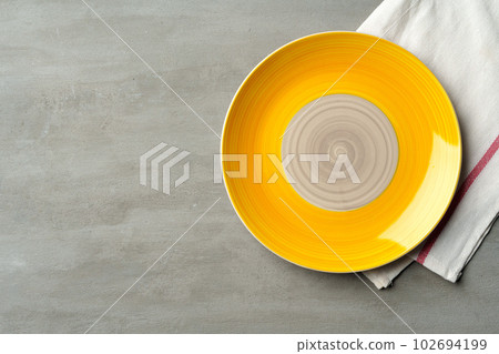 Top view of ceramic plate with table napkin on gray background 102694199
