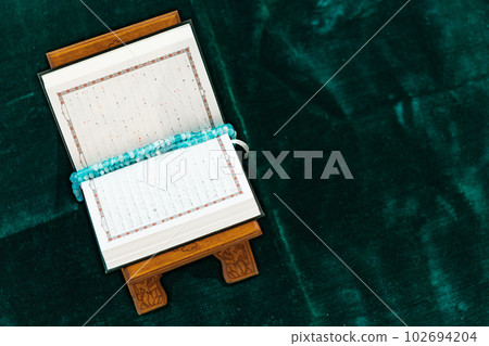 Holy Quran with prayer rosary beads on wooden stand Holy Quran with prayer rosary beads on wooden stand 102694204