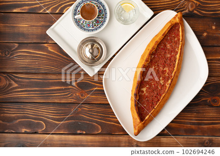 Pide - Turkish baked bread on wooden table Pide - Turkish baked bread on wooden table 102694246