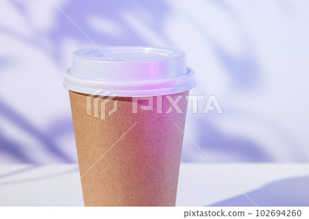 Takeout coffee cup with foliage shadows, copy space 102694260