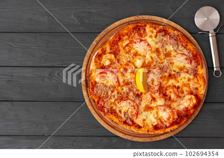 Tasty pizza on black wooden background top view Tasty pizza on black wooden background top view 102694354